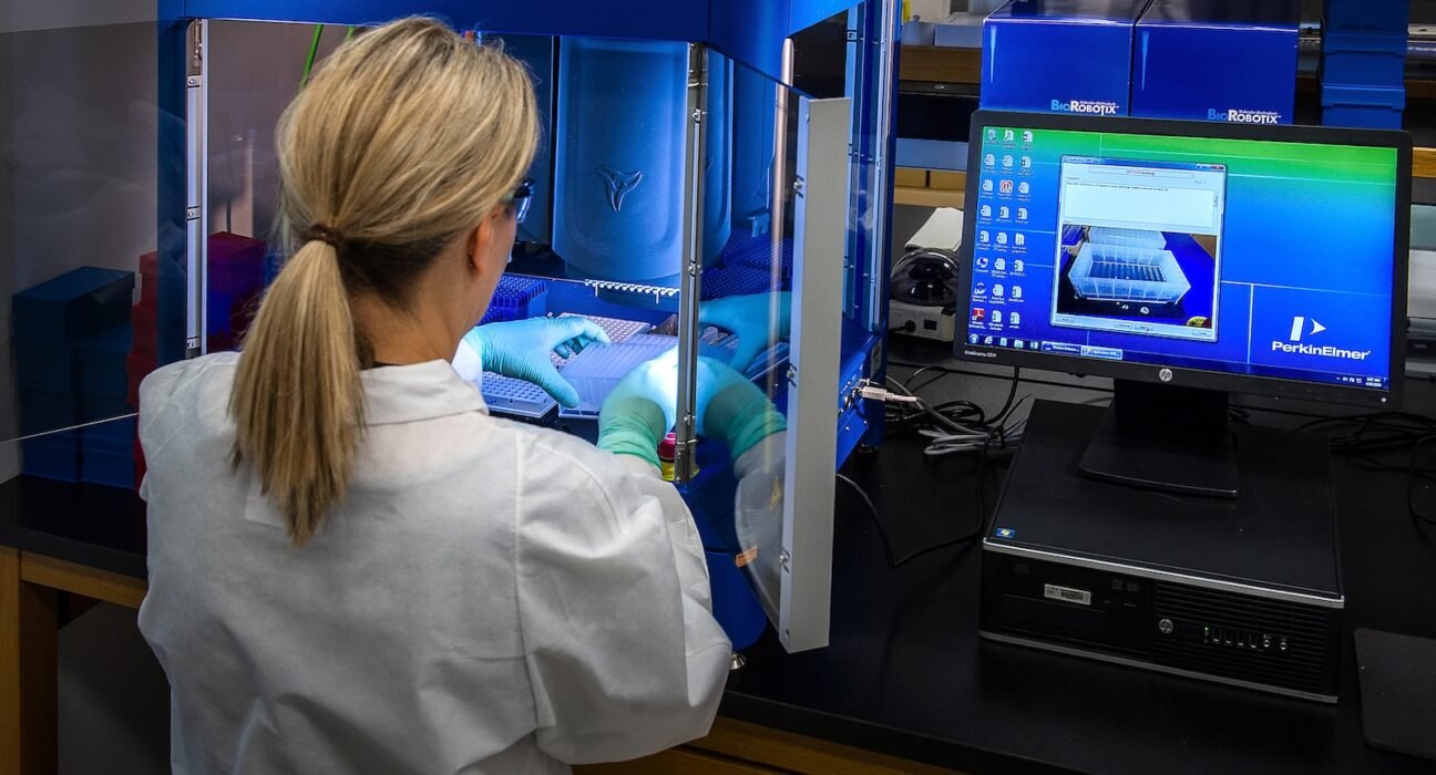 woman in white shirt standing in front of computer Advanced Biomedical Technologies