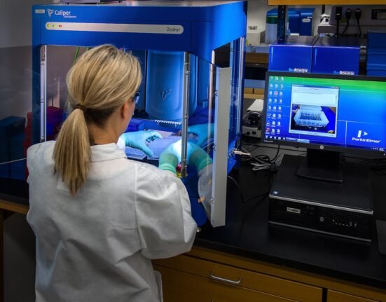 woman in white shirt standing in front of computer Advanced Biomedical Technologies