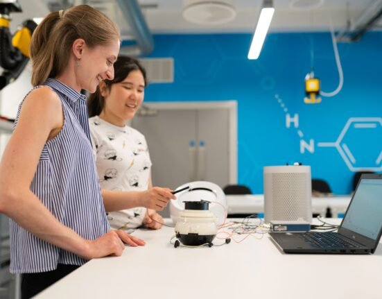 woman in white and black polka dot shirt holding white headphones