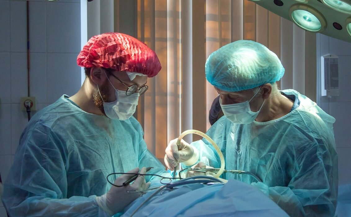 two men wearing blue lab coats